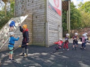 Children rock climbing at Inchmarlo outdoor activity center.