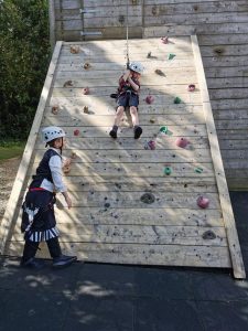 Children climbing outdoor wooden wall at Inchmarlo Adventure Park.