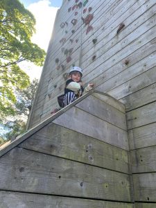 Child enjoying rock climbing activity at Inchmarlo outdoor adventure park.