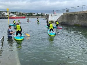 People paddleboarding and kayaking at Inchmarlo water park in Scotland.