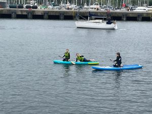 People kayaking on calm water at Inchmarlo estate in Scotland.