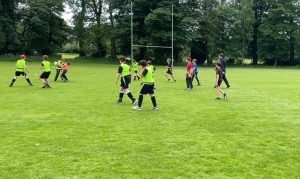 Children playing on the lush green field at Inchmarlo estate, ideal for family outdoor activities and kids' sports.