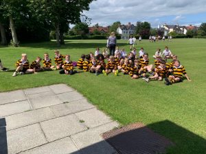 Children in sports uniforms outdoor at Inchmarlo school playing field.