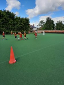Children playing football on school pitch at Inchmarlo School, outdoor sports facility.