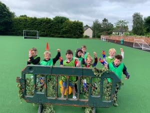 Children enjoying outdoor play at Inchmarlo, surrounded by lush greenery and sports facilities.