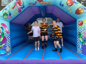 Children playing on a colorful inflatable bounce house at Inchmarlo estate.