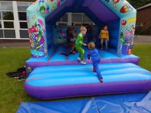 Colorful inflatable bounce house with children playing outdoors at Inchmarlo.