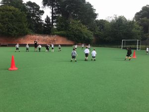 Children playing football on synthetic turf at Inchmarlo outdoor sports facilities.