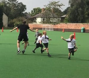 Children playing on Inchmarlo school field with a coach.