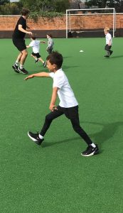 Children playing outdoor sports at Inchmarlo School with teacher supervision.