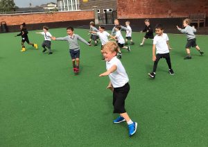 Children playing on bright green sports field at Inchmarlo, enjoying outdoor activities and sports.