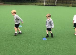 Children playing on green turf at Inchmarlo School outdoor activity zone.