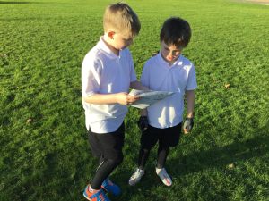 Two children reading outdoors in green park at Inchmarlo.