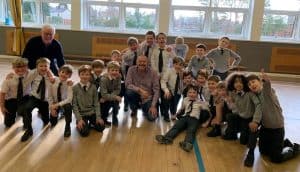 Group of children and teachers in a school hall at Inchmarlo, showcasing a vibrant learning environment.
