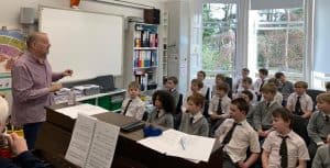 Children learning music with a teacher in classroom setting in Inchmarlo.