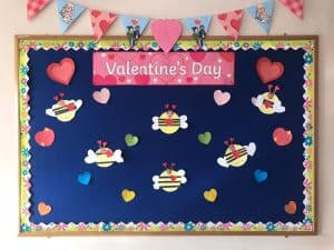 Colorful Valentine’s Day themed bulletin board with hearts and cute bee illustrations.