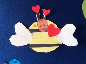 Adorable child craft with hearts, paper wings, and a cheerful face for kids' activities.