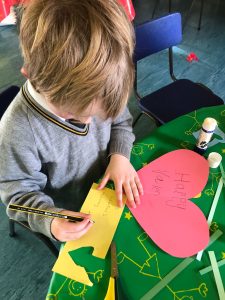 Child making a Valentine’s Day card at Inchmarlo care home in Scotland.