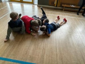 Children playing together on wooden indoor floor at Inchmarlo early learning center.