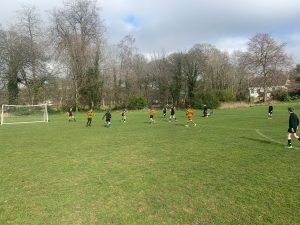 Children playing soccer on lush green field at Inchmarlo estate.