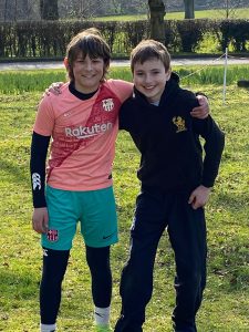 Two children smiling outdoors at Inchmarlo estate in Scotland, enjoying nature and recreation.