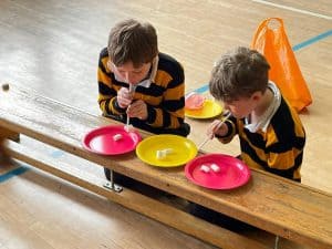 Two children enjoying snack time at Inchmarlo nursery, engaged in a fun eating activity.