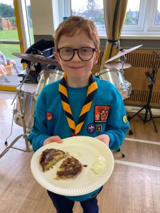Young boy in scout uniform holding a plate of cake at Inchmarlo.