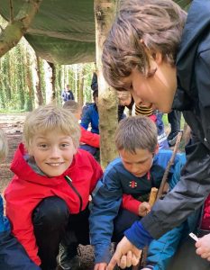 Children enjoying outdoor activities at Inchmarlo in a lush forest setting.