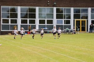 Children playing soccer at Inchmarlo school field, outdoor sports activity, active kids, summer sport day.