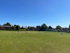 Beautiful view of Inchmarlo golf course with players enjoying a game under clear blue skies.