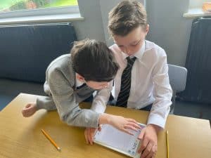 Two young boys studying together at Inchmarlo school, engaged in learning.