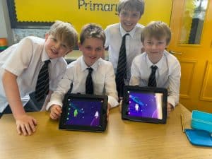 Happy children using tablets in classroom at Inchmarlo.