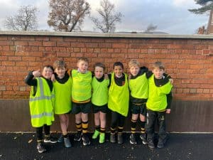 Group of young children in bright yellow safety vests outdoors at Inchmarlo.