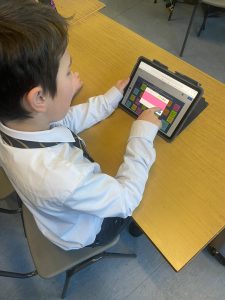 Young boy using tablet for education at Inchmarlo School, technology-enhanced learning experience.