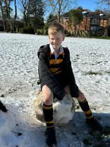 Happy boy playing in snow at Inchmarlo estate, enjoying winter outdoor activities.