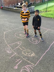 Children playing hopscotch on school playground, outdoors at Inchmarlo.