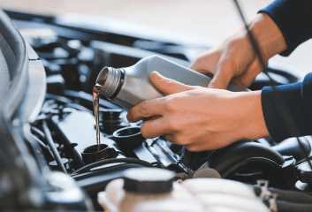 Automotive engine oil being poured during maintenance at Inspired Automotive.