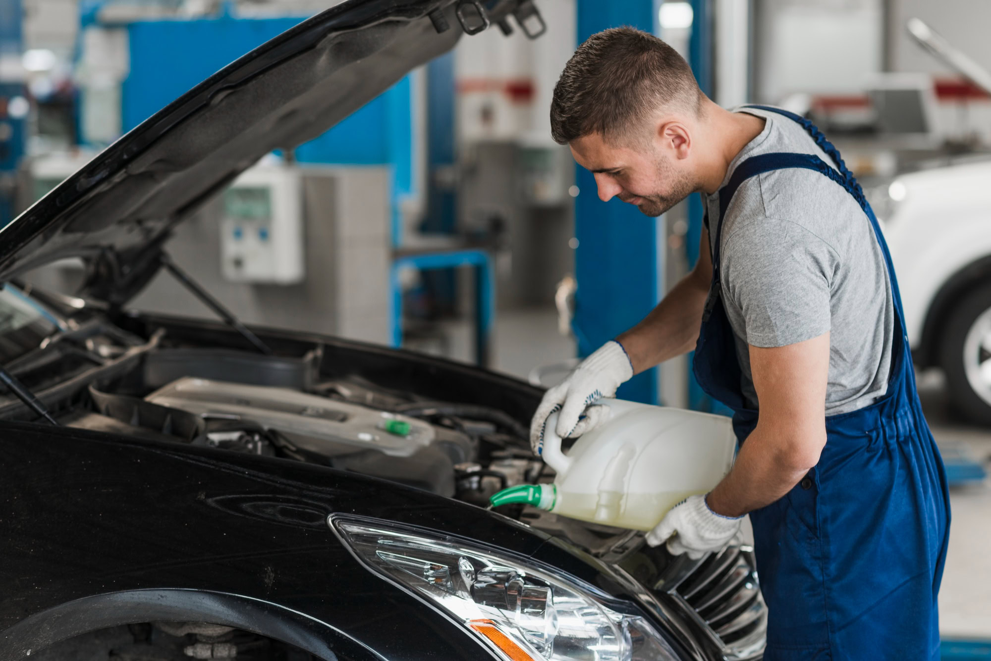Mechanic pouring oil into vehicle