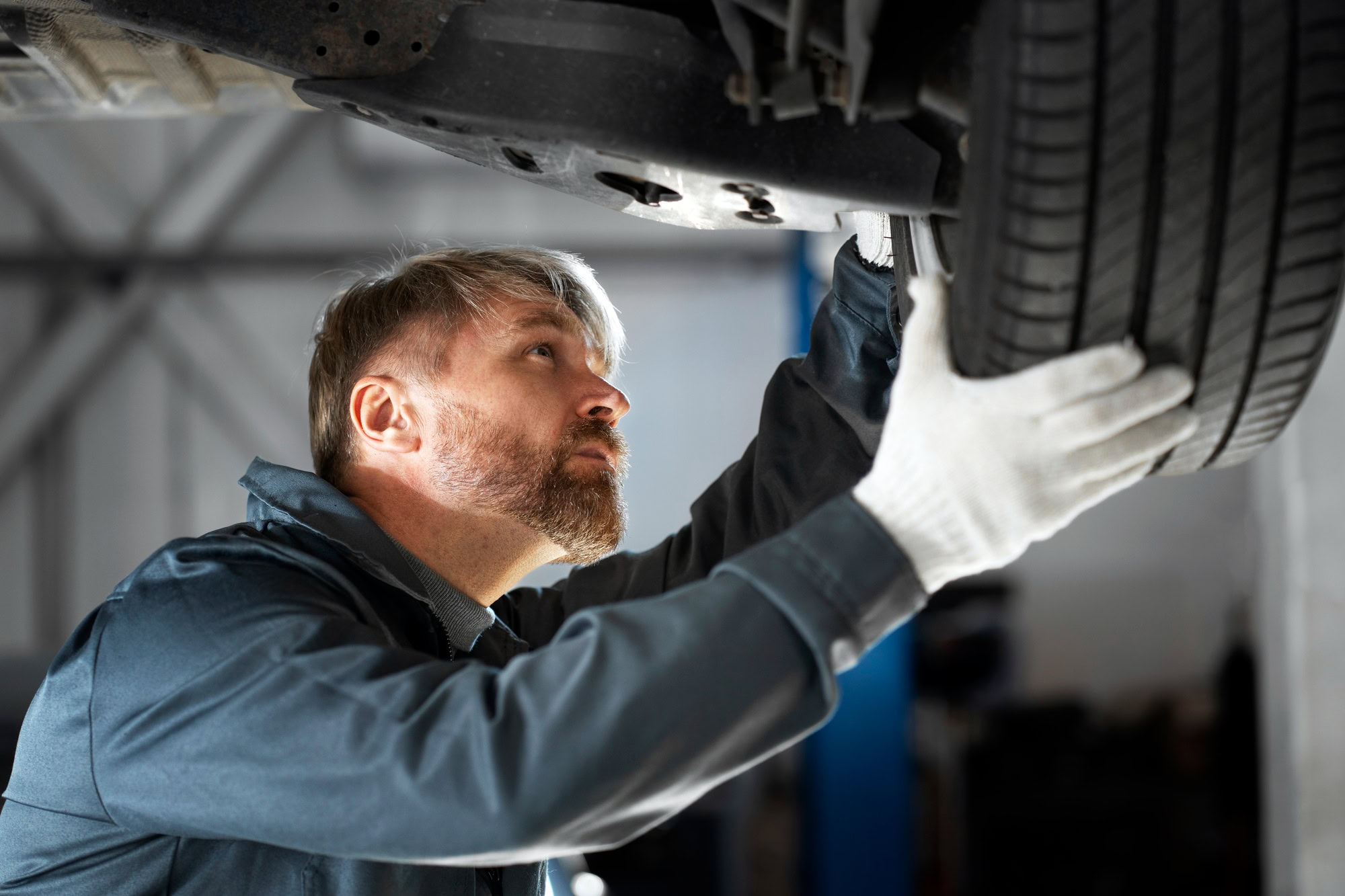 Mechanic examining tire for potential faults