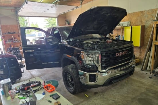GMC truck with open hood in auto repair shop at Izzy's Blue Auto LLC.