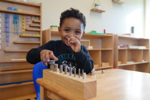 Tools for young children playing with metal bolts and nuts in a classroom setting, Montessori-style educational environment in Jarrell Montessori school.