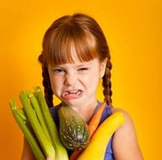 Fresh vegetables and a banana held by a young girl at Jarrell Montessori.