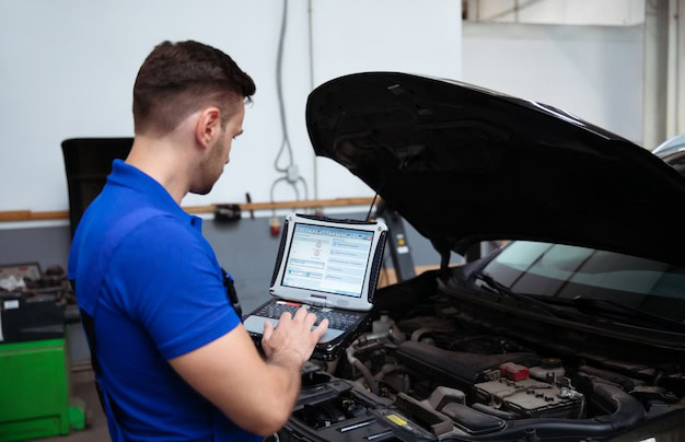 Auto technician diagnosing transmission issues with diagnostic tools in San Leandro.
