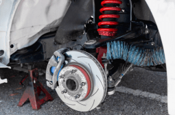 Vehicle suspension repair with new coil spring and brake components.