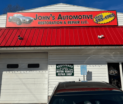 Auto repair shop with red signage and logo featuring a classic car.