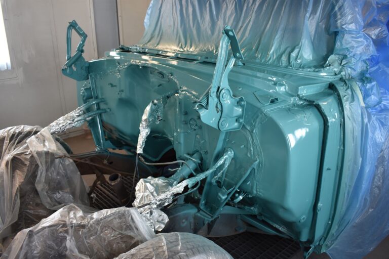 Classic car body being restored with fresh paint and primer.