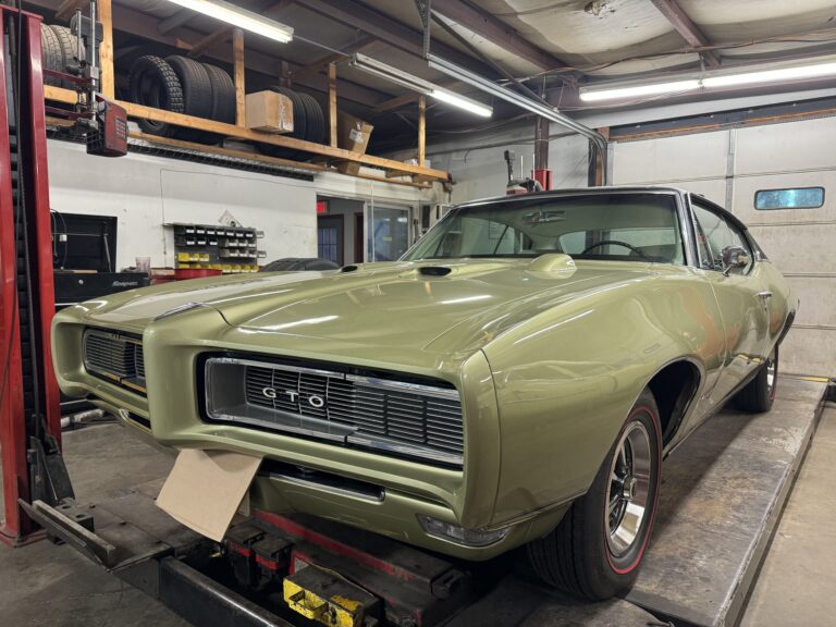 Restored 1969 Pontiac GTO in a sleek green finish, showcasing expert craftsmanship and attention to.