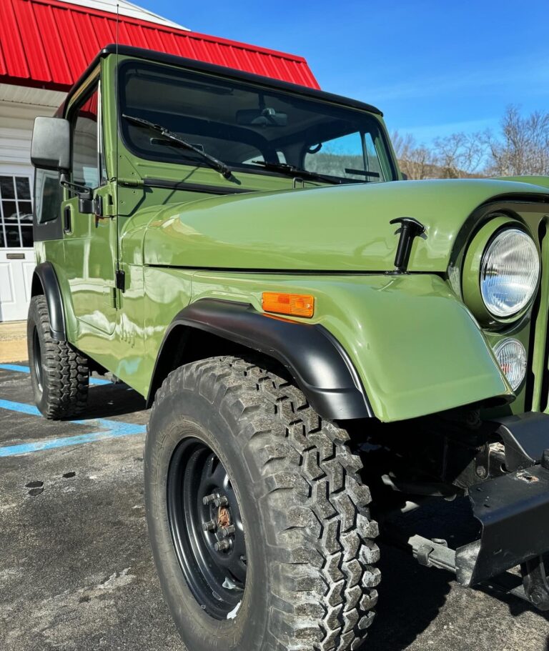 Green off-road vehicle at John's Auto Restoration shop.