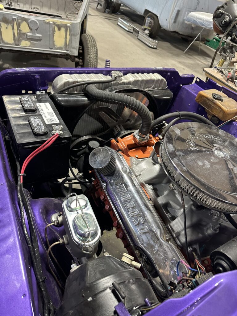 Engine bay of a classic car undergoing restoration at John's Automotive.