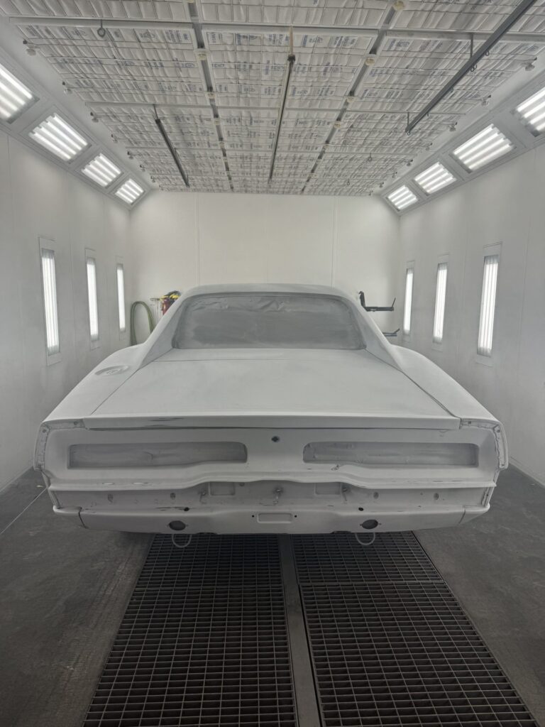 Classic car in paint booth ready for finishing touches.